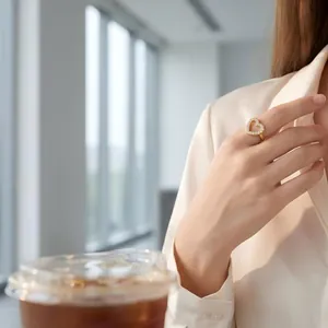 Elegante lifestyle-weergave van een vergulde hartring met fonkelende stenen om een vinger.
