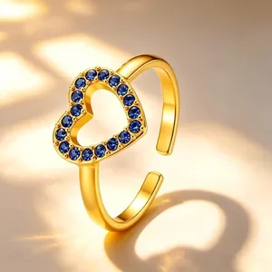 Detailopname van een vergulde hartvormige ring bezet met levendige blauwe kristallen.