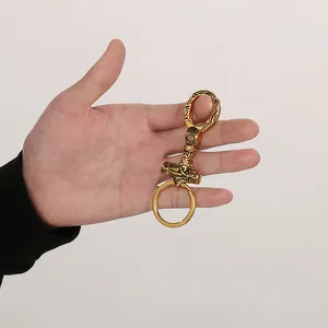 Portachiavi vintage martello di Thor vichingo oro con rilievi mostrato in mano.