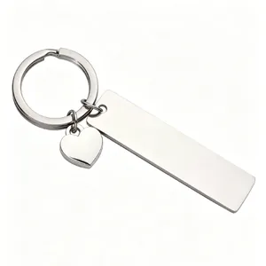 Macro detail showing the polished mirror finish of the stainless steel bar and heart charm keychain
