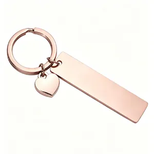 Close-up of rose gold stainless steel bar and heart charm keychain with mirror finish