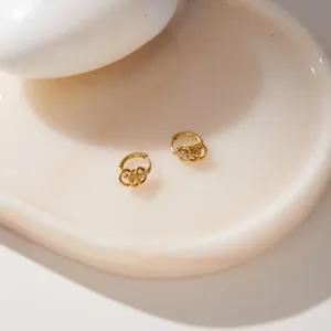 Close-up of gold titanium steel hoop earrings with multi-ring zircon details.