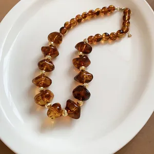 Collier de perles en acrylique ambre translucide avec des séparateurs dorés élégants