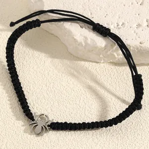 Detailed close-up showing the texture of the black braided rope and silver spider charm on bracelet