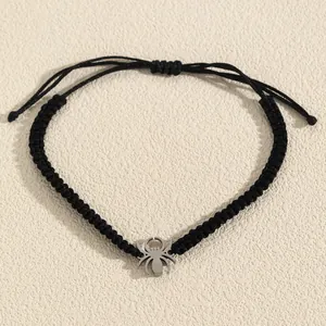 Detailed view of handcrafted black woven adjustable bracelet with silver spider pendant