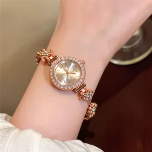 Close-up detail of an elegant rose gold flower bracelet watch with sparkling crystals.