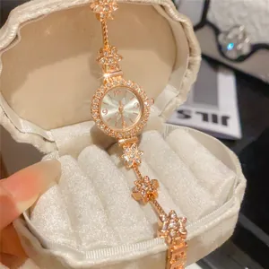 Close-up detail of a rose gold floral bracelet watch with shimmering rhinestone accents