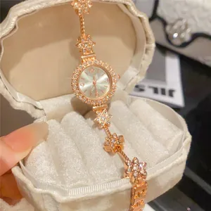 Elegant rose gold floral watch with crystal accents displayed in a white velvet shell box