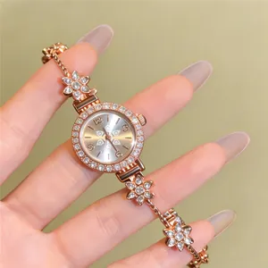 Detailed close-up shot of an elegant rose gold rhinestone flower bracelet watch on hand