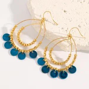 Detailed macro view of vintage boho double-layer teardrop hoop earrings with blue sequins