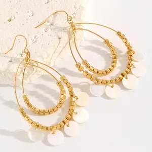 Close-up of vintage double-layer teardrop earrings with white shell tassels