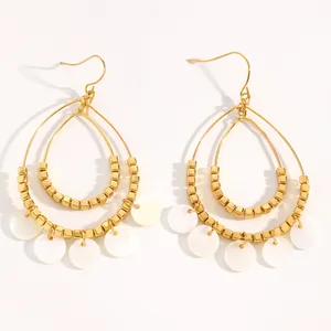 Vintage ethnic gold teardrop hoop earrings with white shell charms in a detailed view