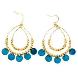 Close-up detail of ethnic double-layer teardrop earrings with blue shell charms