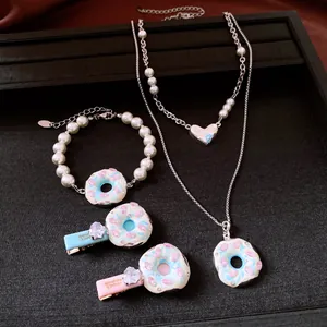 Detailansicht eines modischen Schmucksets mit Perlenarmband und Donut-Halsketten mit Kristallen