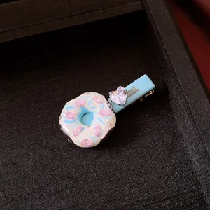 Nahaufnahme einer blauen Donut-Haarspange mit rosa Zirkon und Herz-Kristall-Detail
