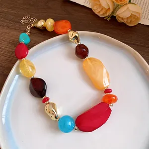 Vue détaillée du collier de perles géométriques en acrylique coloré sur une assiette