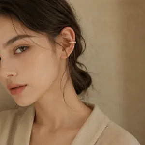 Close-up of elegant gold plated zircon ear cuff worn by a model in a minimalist style