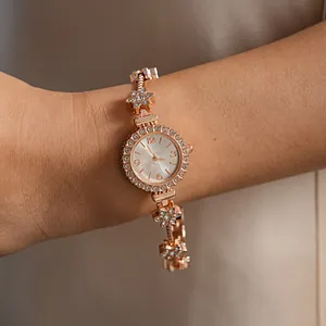 Elegant rose gold bracelet watch with sparkling rhinestone flower design shown on wrist
