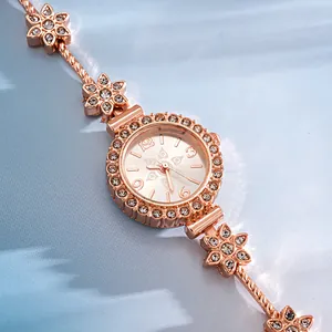 Close-up of elegant rose gold flower bracelet watch with sparkling rhinestones.