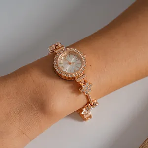 Detailed close-up of a luxury rose gold rhinestone flower bracelet watch on wrist