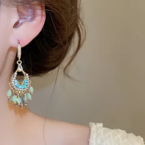 Detailansicht böhmischer Goldquasten-Ohrringe mit grünen Zirkonia und Perlen.