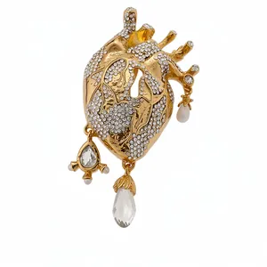 Luxurious anatomical heart brooch featuring sparkling crystals and pearl dangles in gold