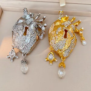 Detailed view of rhinestone anatomical heart brooches in gold and silver finishes