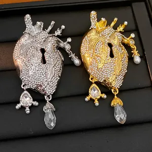 Close-up of gold and silver anatomical heart brooches with rhinestones and crystals