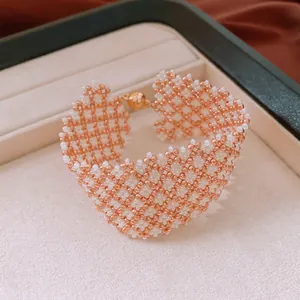 Detaillierte Nahaufnahme eines gewebten Glasperlenarmbands mit goldenem Magnetverschluss.