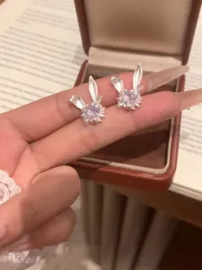 Vista detallada de pendientes de conejo de plata con un centro brillante de circón de corazón