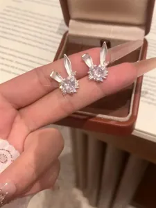 Detalle de pendientes de conejo brillantes con piedra de circón en forma de corazón