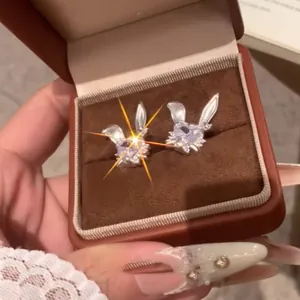 Primer plano de brillantes pendientes de conejo con circonitas en una caja de regalo