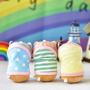 Πίσω όψη τριών βελούδινων μπρελόκ γάτας με πολύχρωμα ριγέ και πουά ρούχα σε φωτεινό φόντο