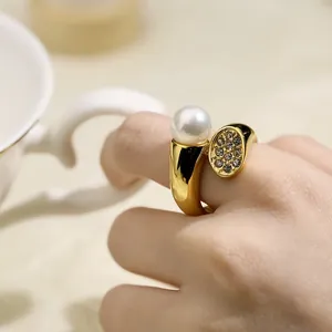 Elegant vintage 18K gold plated pearl ring with pavé crystals on a model finger.