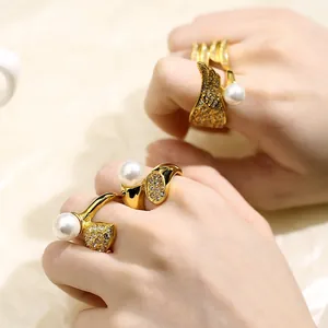 Detailed view of vintage 18k gold plated stainless steel pearl rings on female hands