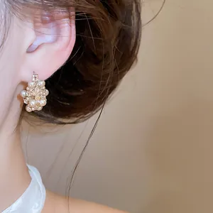 Detailansicht eines eleganten Vintage-Blumenkorb-Ohrrings mit Perlen und Strass