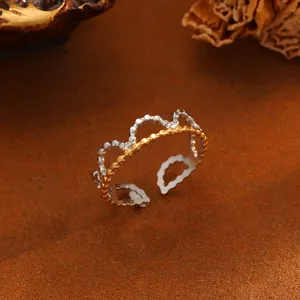 Detailaufnahme eines zweifarbigen Titanstahl-Kronenrings mit wellenförmigem Perlendesign