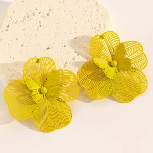 Detailed macro view of oversized hollow yellow flower earrings with a double-layer design