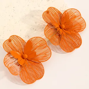 Detail view of vibrant orange oversized hollow double-layer flower jewelry set earrings