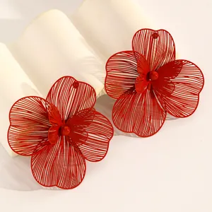 Oversized red openwork floral earrings with layered petal design and fine wire details.