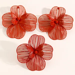 Detailed view of oversized red hollow flower jewelry set with earrings and ring