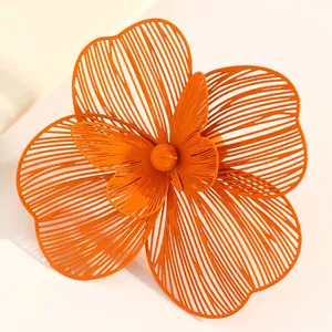 Macro view of oversized orange hollow flower accessory with intricate double-layer petals