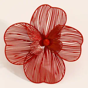 Close-up of oversized red hollow double-layer flower jewelry with intricate wire design