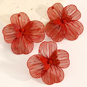 Detail view of red oversized hollow double-layer flower jewelry set on a stone surface