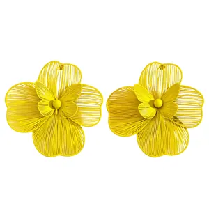 Detailed macro view of oversized yellow hollow flower earrings with butterfly center motifs
