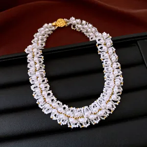 Dettaglio di collana di perle intrecciate stile vintage con perle dorate su espositore