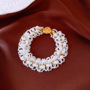 Dettaglio del bracciale di perle fatto a mano con elegante chiusura dorata vintage.
