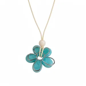 Collier minimaliste avec pendentif fleur en résine turquoise et cordon crème, style dopamine