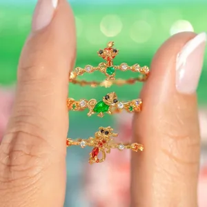 Detailansicht von drei vergoldeten Ringen mit bunten Zirkonia-Trickfilmfiguren.