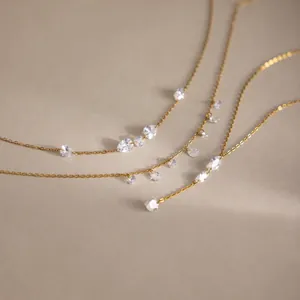 Primo piano del collana in acciaio dorato 18K con zirconi trasparenti a goccia